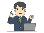 スーツを着た男性スタッフがパソコンに向かいながら電話の受話器を耳に当てて話している